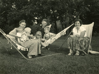 Emily and Whittier Day relaxing with their children in a hammock at the home of Grace Weyker in Bloomington, 1951.