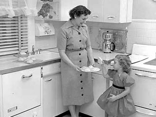 Women and girl in kitchen with a plate of pastries, 1955. Loc. no. GT3.13 p41