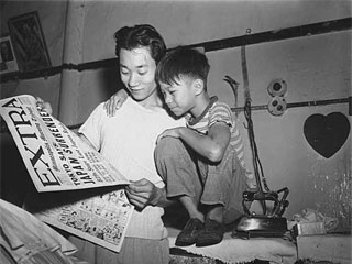 Man and boy reading about Japan's surrender, VJ Day, 1945. Loc. no. E448.17 r11