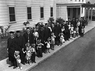 Fathers in caps and gowns with their children, University Village, St. Paul, 1951. Loc. no. FM6.833 p11 