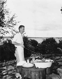 Man cooking on an outdoor grill, 1955.