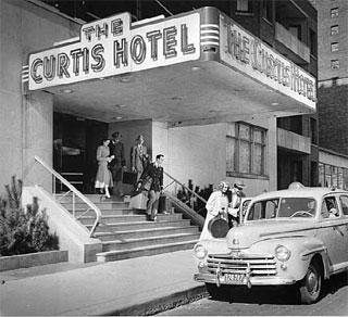 Photo: Guests leaving Curtis Hotel with bellhop, Minneapolis, 1948.