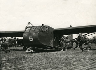 Glider riders emerge from a landed glider in a training exercise.