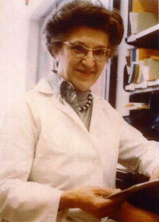 Bee Hanlon, wearing a lab coat, in her office at the University of Minnesota, ca. 1970s.