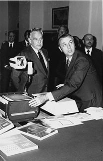 Carl A. Kuhrmeyer demonstrates the 3M overhead projector for Prince Ranier of Monaco. 