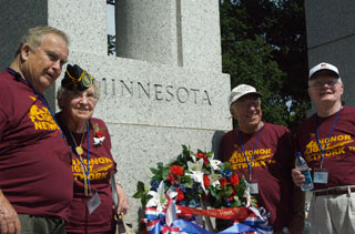 Photo: Minnesota's WWII veterans pose in front of the Minnesota Pillar at the World War II Memorial.