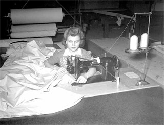 Photo: Seamstress at machine, Northwest Aeronautical Corporation plant, Holman Field, St. Paul, ca. 1942.