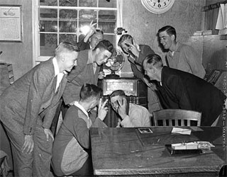 Group gathered around office radio, VJ Day, 1945.