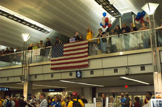 Photo: An enthusiastic crowd welcomed the World War II veterans home from their trip at Minneapolis/St. Paul International Airport.